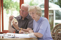 An older couple studying at a table together