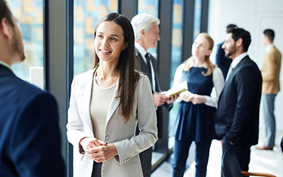 People in suits standing talking to each other in an office