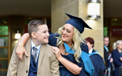 An OU graduate and ceremony guest celebrate outside Glasgow Royal Concert Hall.