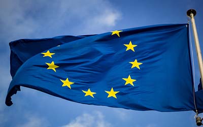 European Union flag on a flag pole, with sky in background