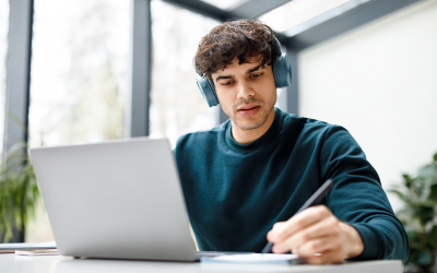 A man working on his laptop with headphones on